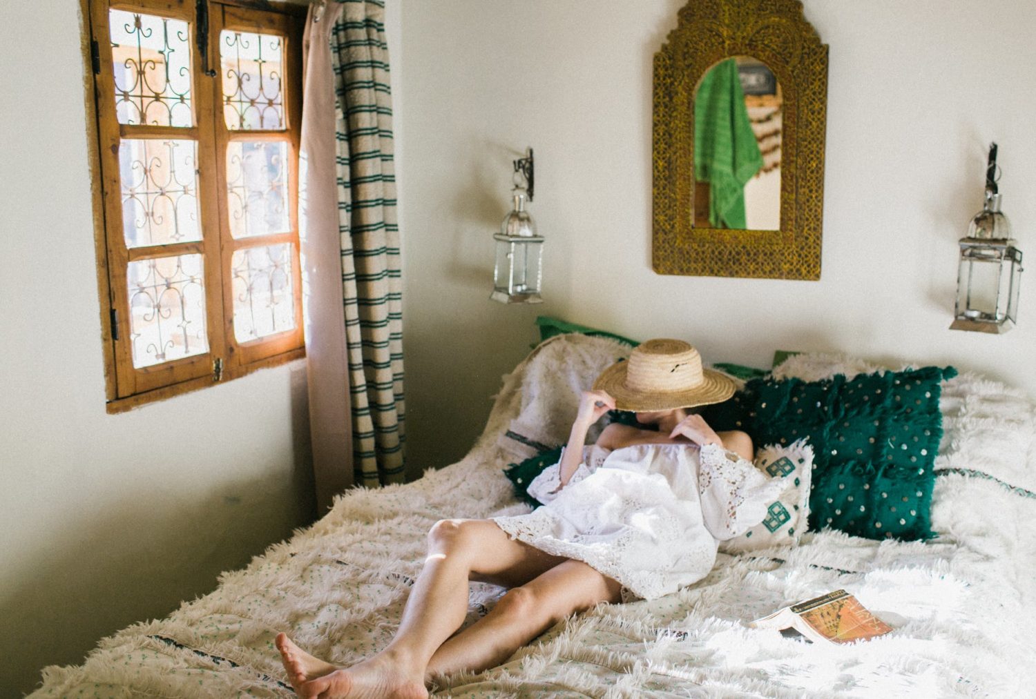 woman in sundress resting on bed on oriental room