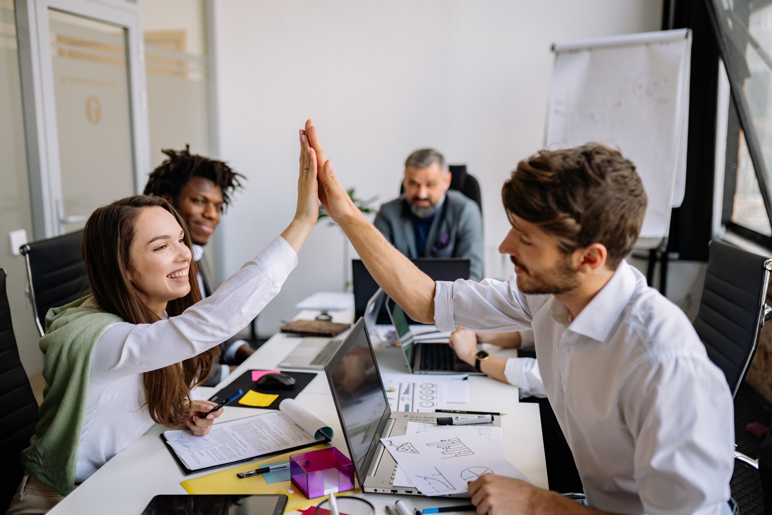 man and woman doing high five during a meeting shows good team environment