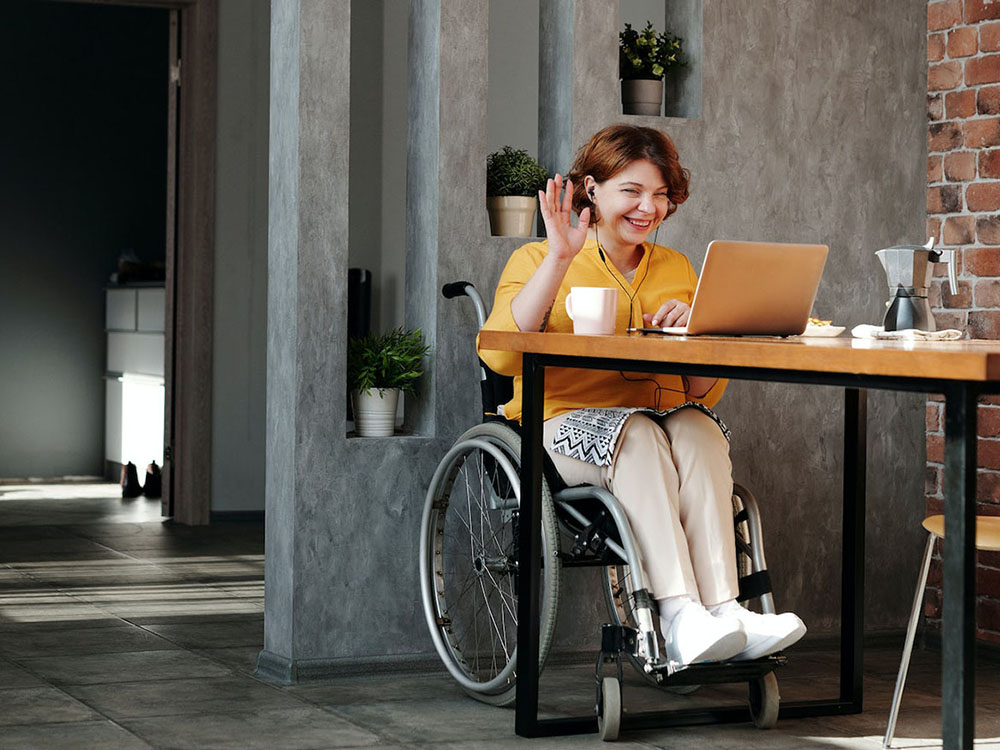 person in a wheelchair working on a laptop